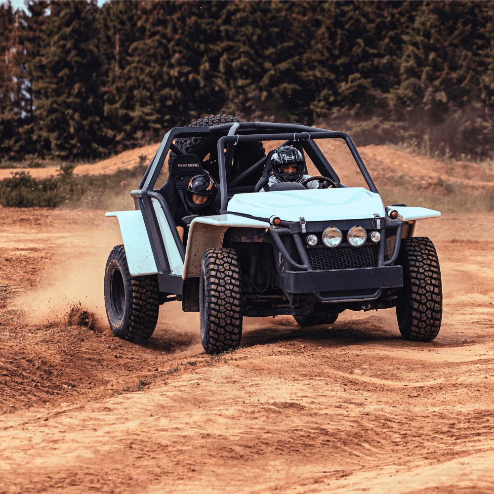 Na zdjęciu widać pojazd off-roadowy jadący dynamicznie po piaszczystej trasie, dodając adrenaliny entuzjastom motoryzacji.