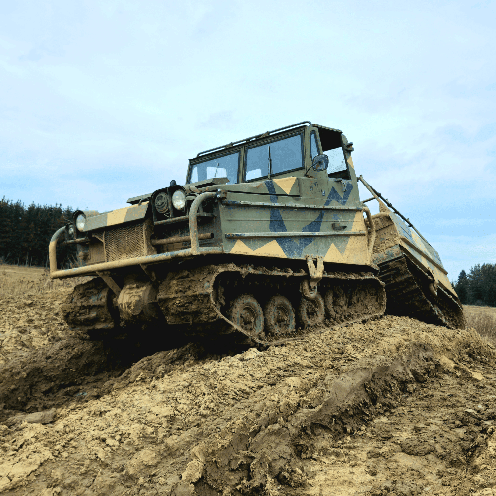 Gąsienicowy pojazd batalistyczny pokonuje błotniste wzniesienie oferując ekstremalne przeżycia dla pasjonatów monster trucków na terenie Gassy pod Warszawą.
