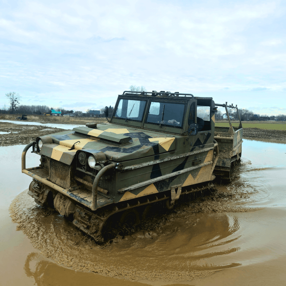 Na grafice widać pojazd terenowy poruszający się przez błotnisty teren, idealny dla fanów monster trucków w każdym wieku.