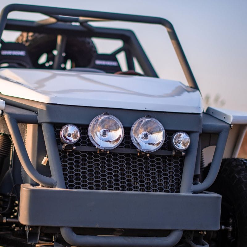 Na zdjęciu znajduje się zbliżenie na przód terenowego pojazdu z solidnym oświetleniem, co przywodzi na myśl atrakcje związane z mocarnymi monster truckami, oferowane w okolicach Warszawy.
