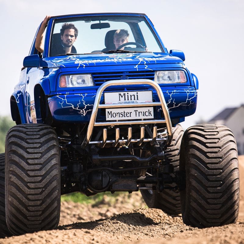 Na zdjęciu widać niebieskiego mini monster trucka przemierzającego piaszczysty teren, oferującego emocje dla miłośników ekstremalnych atrakcji w Gassy koło Warszawy.