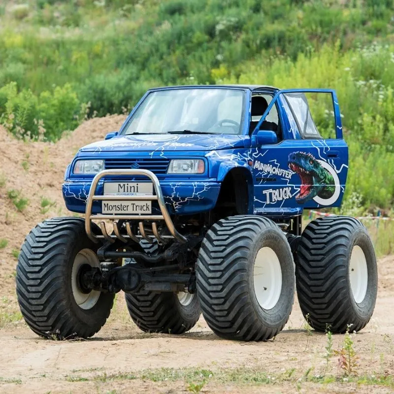 Na zdjęciu widać mini monster trucka na tle plenerowego terenu, co idealnie wpisuje się w atrakcje dla fanów motoryzacyjnych wrażeń w każdej grupie wiekowej.